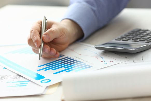 Foto: Person zeigt mit Stift auf Akten